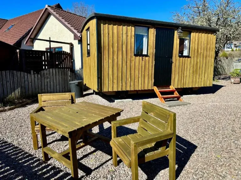 Bespoke shepherd’s hut built in Fort William, Scotland, with timber cladding and outdoor seating.
