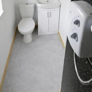 Shepherd’s hut bathroom with custom lino flooring, toilet, sink unit and electric shower