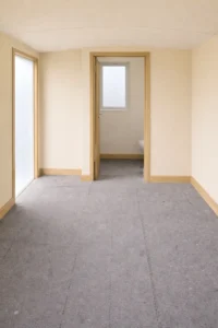 Shepherd’s hut interior with light cream wall finish, timber trim and partitioned bathroom layout