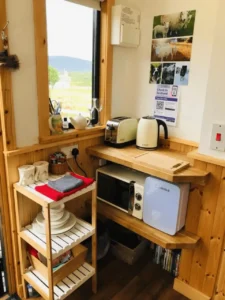 Shepherd’s hut kitchenette with kettle, toaster, microwave and storage shelves