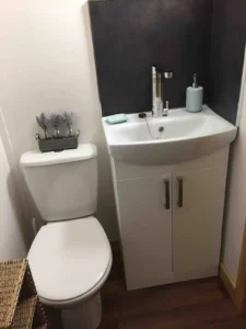 Shepherd’s hut bathroom with toilet, sink unit and storage