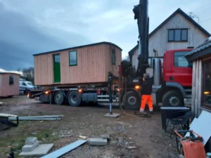 Shepherd’s hut delivery using crane lorry showing transport and on-site positioning