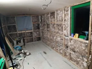 Shepherd’s hut under construction showing wall framing, insulation and electrical wiring before internal finish