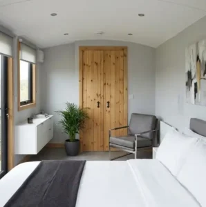 Clean modern bedroom and lounge area in shepherd's hut