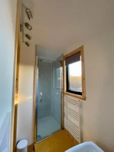Shepherd’s hut bathroom with shower enclosure, towel radiator and window