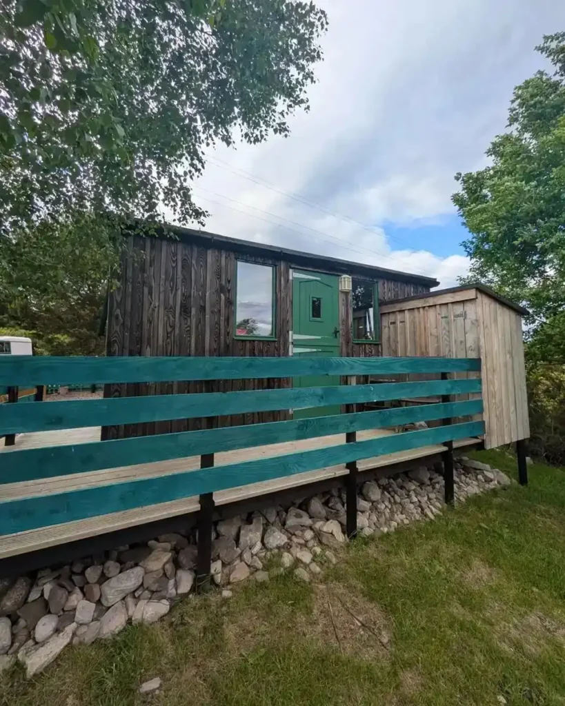 Brambles shepherds hut side exterior green fence