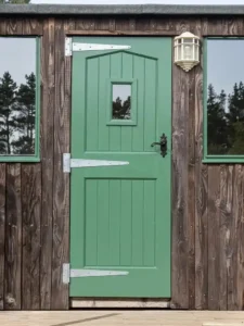 Small glazed green shepherds hut door