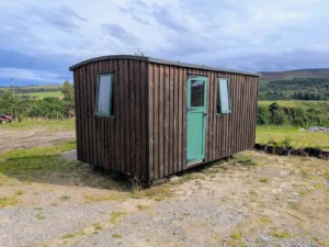 Weathered timber shepherds hut green door